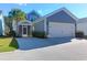 Home exterior featuring a spacious garage, screened porch, palm tree, and well-manicured lawn at 2909 Swamp Sparrow Cir, Johns Island, SC 29455