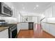 Modern kitchen with white cabinets, stainless steel appliances, hardwood floors, granite countertops, and tile backsplash at 2909 Swamp Sparrow Cir, Johns Island, SC 29455
