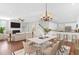 Open-concept living space with dining area, kitchen, hardwood floors, fireplace, and staircase at 2909 Swamp Sparrow Cir, Johns Island, SC 29455