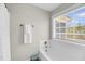 Bright bathroom features a white tiled tub and shower, a window, and neutral decor at 2919 Zachary George Ln, Johns Island, SC 29455