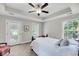 Bright bedroom features white bedding, tray ceilings, a ceiling fan, and windows allowing natural light at 2919 Zachary George Ln, Johns Island, SC 29455