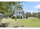 Beautiful blue two-story house featuring a manicured lawn and lush landscaping at 2919 Zachary George Ln, Johns Island, SC 29455