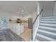Bright kitchen with stainless steel appliances and white cabinetry adjacent to staircase with gray accents at 2954 Woodland Park Dr, Mount Pleasant, SC 29466