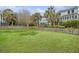 Expansive backyard with well-maintained lawn, mature trees, and a privacy fence, perfect for outdoor activities at 303 S Ladd Ct, Charleston, SC 29492