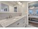 Bathroom featuring double sinks, a large mirror, and access to the main bedroom at 303 S Ladd Ct, Charleston, SC 29492