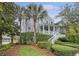 Charming home exterior with a welcoming front porch and lush tropical landscaping at 303 S Ladd Ct, Charleston, SC 29492
