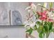 Close up view of white and pink lillies in a clear glass vase with a modern abstract painting in the background at 303 S Ladd Ct, Charleston, SC 29492