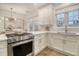 Well-lit kitchen featuring stainless steel gas range, white cabinets, quartz countertops, and stylish backsplash at 303 S Ladd Ct, Charleston, SC 29492