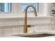 Modern kitchen faucet with white subway tile backsplash, marble countertop, and window in the background at 303 S Ladd Ct, Charleston, SC 29492