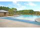 Large community pool with ample lounge chairs, palm trees, and a bath house for residents' enjoyment at 309 Peters Creek Dr, Summerville, SC 29486