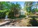 Charming single-story home featuring a sunroom, mature landscaping, and a brick-lined walkway leading to the entrance at 328 Fern House Walk, Mount Pleasant, SC 29464