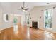 Bright living room with a granite fireplace, hardwood floors, and large windows overlooking the yard at 328 Fern House Walk, Mount Pleasant, SC 29464