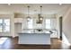 Open kitchen with a large island, white cabinets, stainless appliances, and stylish pendant lights at 366 Trailmore Ln, Summerville, SC 29486