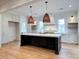 Elegant open kitchen with stone countertops, a dark center island, and rattan pendant lights at 3894 Summerton St, Mount Pleasant, SC 29466