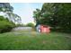 Expansive backyard featuring lush greenery and a versatile storage shed at 406 Annette Dr, Goose Creek, SC 29445