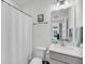 Clean bathroom features a single sink vanity, toilet, and shower with a white curtain at 4414 Avery Ave, North Charleston, SC 29405