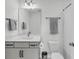 Well-lit bathroom featuring a gray vanity with sleek hardware, a toilet, and a bathtub with gray shower curtain at 4414 Avery Ave, North Charleston, SC 29405