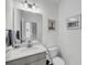 Half bathroom featuring a gray vanity, mirror, a toilet, and wall decor at 4414 Avery Ave, North Charleston, SC 29405