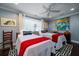 Cozy bedroom with twin beds, red accents, blue walls, a ceiling fan, and a window with natural light at 4940 Lambs Road Rd, North Charleston, SC 29418