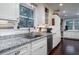 Bright kitchen featuring granite countertops, stainless steel appliances, and white cabinets and dark hardwood flooring at 4940 Lambs Road Rd, North Charleston, SC 29418