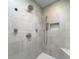 A modern shower with a rainfall shower head, handheld sprayer, bench seat, and a decorative tiled niche at 4940 Lambs Road Rd, North Charleston, SC 29418