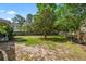Lush backyard with mature trees, a wood fence, and ample space for outdoor activities at 5413 Barnsley Dr, North Charleston, SC 29420