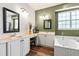 Bright bathroom with a dual sink vanity, decorative mirrors, and a large tub at 5413 Barnsley Dr, North Charleston, SC 29420