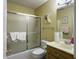 Bathroom with a sliding glass shower door, floral decor, and wood grain vanity at 5505 Indigo Makers Trce, Charleston, SC 29418