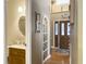 Hallway view with a half bathroom to the left, leading to a wooden double-door entrance at 5505 Indigo Makers Trce, Charleston, SC 29418