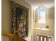Elegant landing with an arched window and decorative tapestry, bathed in natural light, near wooden stairs at 5505 Indigo Makers Trce, Charleston, SC 29418