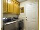Functional laundry room with modern washer and dryer, and overhead cabinets at 5505 Indigo Makers Trce, Charleston, SC 29418