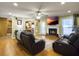 Inviting living room featuring a cozy fireplace, hardwood floors, and comfortable leather recliners at 5505 Indigo Makers Trce, Charleston, SC 29418
