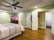 Light-filled main bedroom features a ceiling fan, wood floors, and ensuite bathroom at 5505 Indigo Makers Trce, Charleston, SC 29418