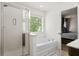 Bright bathroom featuring a shower, a separate soaking tub, and a window providing natural light at 558 Wynfield Forest Dr, Summerville, SC 29485