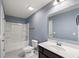 Bathroom with tub-shower combo, large mirror, and white single sink vanity at 629 Snow Owl Dr, Summerville, SC 29486