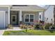 Close-up of home's entry with well-kept lawn, flower bed, and charming front porch at 629 Snow Owl Dr, Summerville, SC 29486