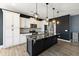 Modern kitchen features black island with marble top, white cabinets, and stainless steel appliances at 629 Snow Owl Dr, Summerville, SC 29486