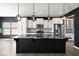 Modern kitchen features black island with marble top, white cabinets, and stainless steel appliances at 629 Snow Owl Dr, Summerville, SC 29486