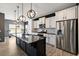 Modern kitchen features black island with marble top, white cabinets, and stainless steel appliances at 629 Snow Owl Dr, Summerville, SC 29486