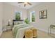 Bright bedroom with a ceiling fan, two windows, neutral decor and two bedside tables at 656 Coleman Blvd # 405, Mount Pleasant, SC 29464