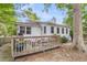 Back of home featuring a wooden deck, lush landscaping, and mature tree at 7 Sconesill Ln, Charleston, SC 29414