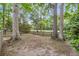 View of a large fenced backyard with mature trees and view of greenery beyond the fence at 7 Sconesill Ln, Charleston, SC 29414