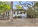 Back of home featuring a wooden deck, lush landscaping, and mature tree at 7 Sconesill Ln, Charleston, SC 29414