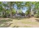Back of the home showcasing the fenced-in yard, green lawn, and mature trees at 7 Sconesill Ln, Charleston, SC 29414