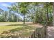 View of lush green fairway from backyard with wood fence in foreground at 7 Sconesill Ln, Charleston, SC 29414