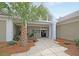 Inviting clubhouse entrance with palm trees, lush landscaping, and a covered walkway, enhancing the welcoming atmosphere at 7 Sconesill Ln, Charleston, SC 29414