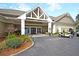 Inviting clubhouse entrance with a well-maintained exterior, covered entry, golf cart parking, and landscaping at 7 Sconesill Ln, Charleston, SC 29414