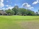 A vibrant green golf course with the residence nestled in the trees in the background at 7 Sconesill Ln, Charleston, SC 29414