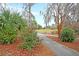 Scenic golf path surrounded by lush greenery, mature trees, and flowering bushes, providing a tranquil atmosphere at 7 Sconesill Ln, Charleston, SC 29414