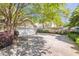 Spacious driveway leading to a two-car garage, surrounded by blooming azaleas and mature trees at 707 Royall Ave, Mount Pleasant, SC 29464